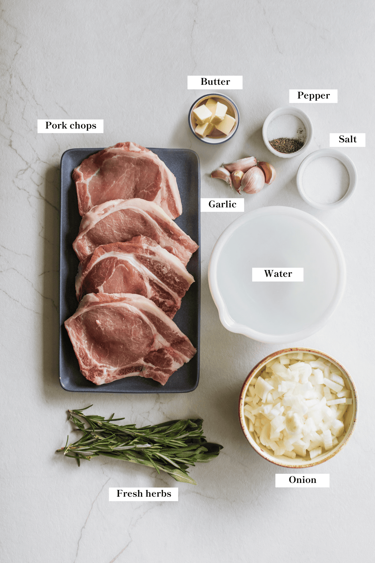 Ingredients to make pork chops laid out on a counter top.