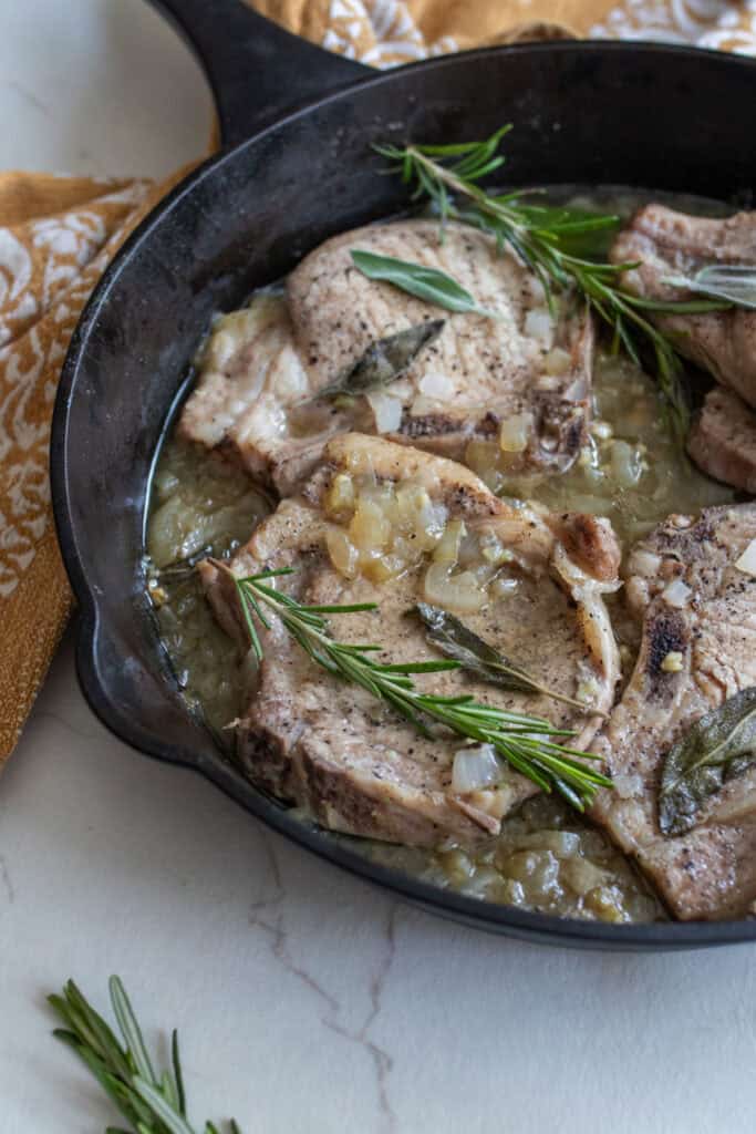 Pork chops in gravy with herbs and onions.