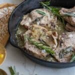 pork chops smothered in gravy in a cast iron skillet.