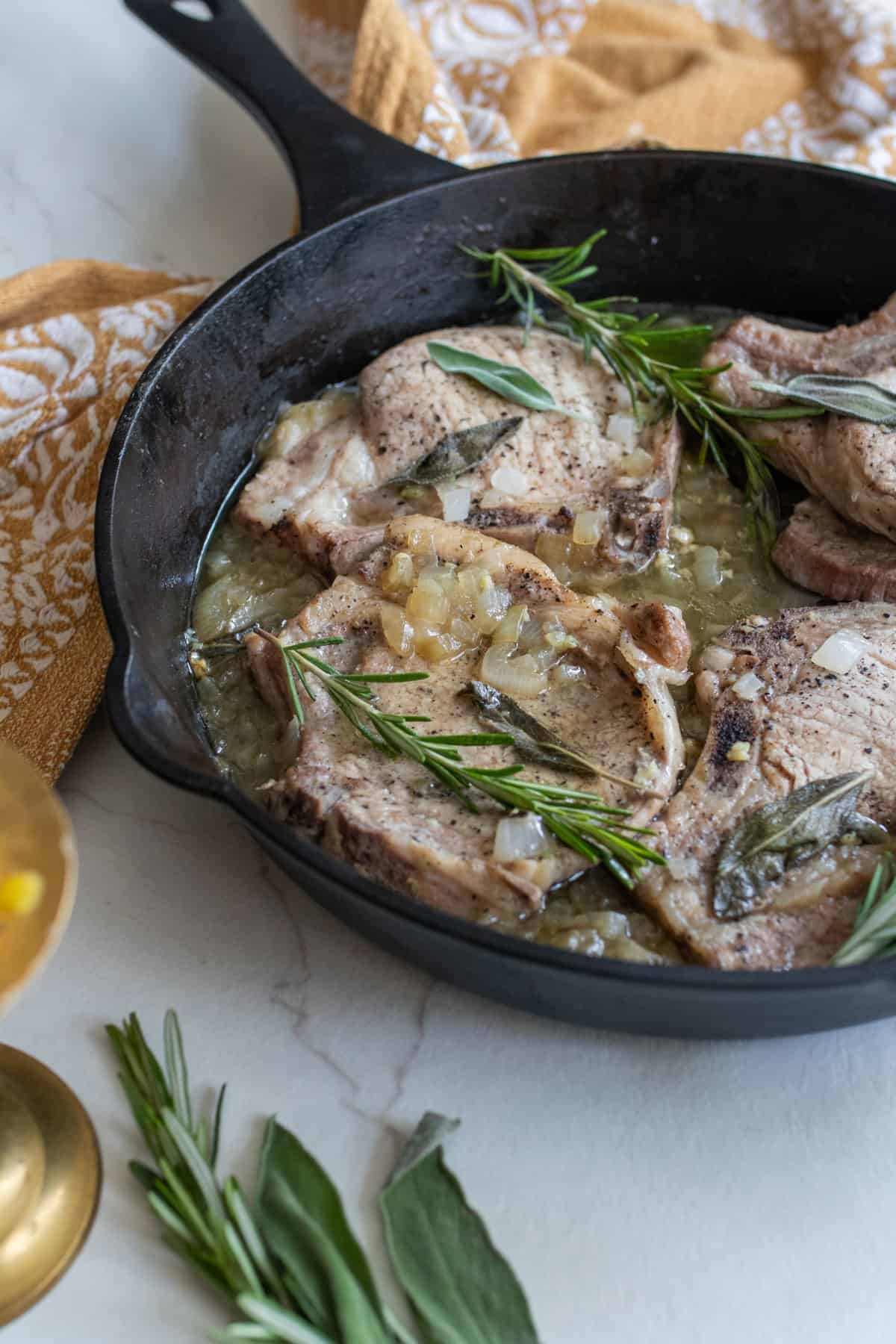 Pork chops smothered in gravy in a cast iron skillet.