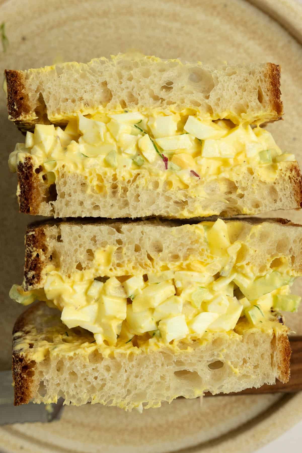 An egg salad sandwich cut in half.