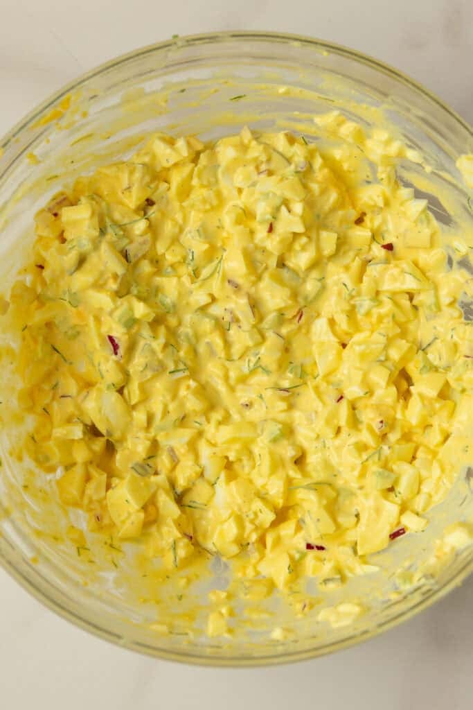 Chopped eggs, onion, celery, mayo, and pickles mixed together until creamy.