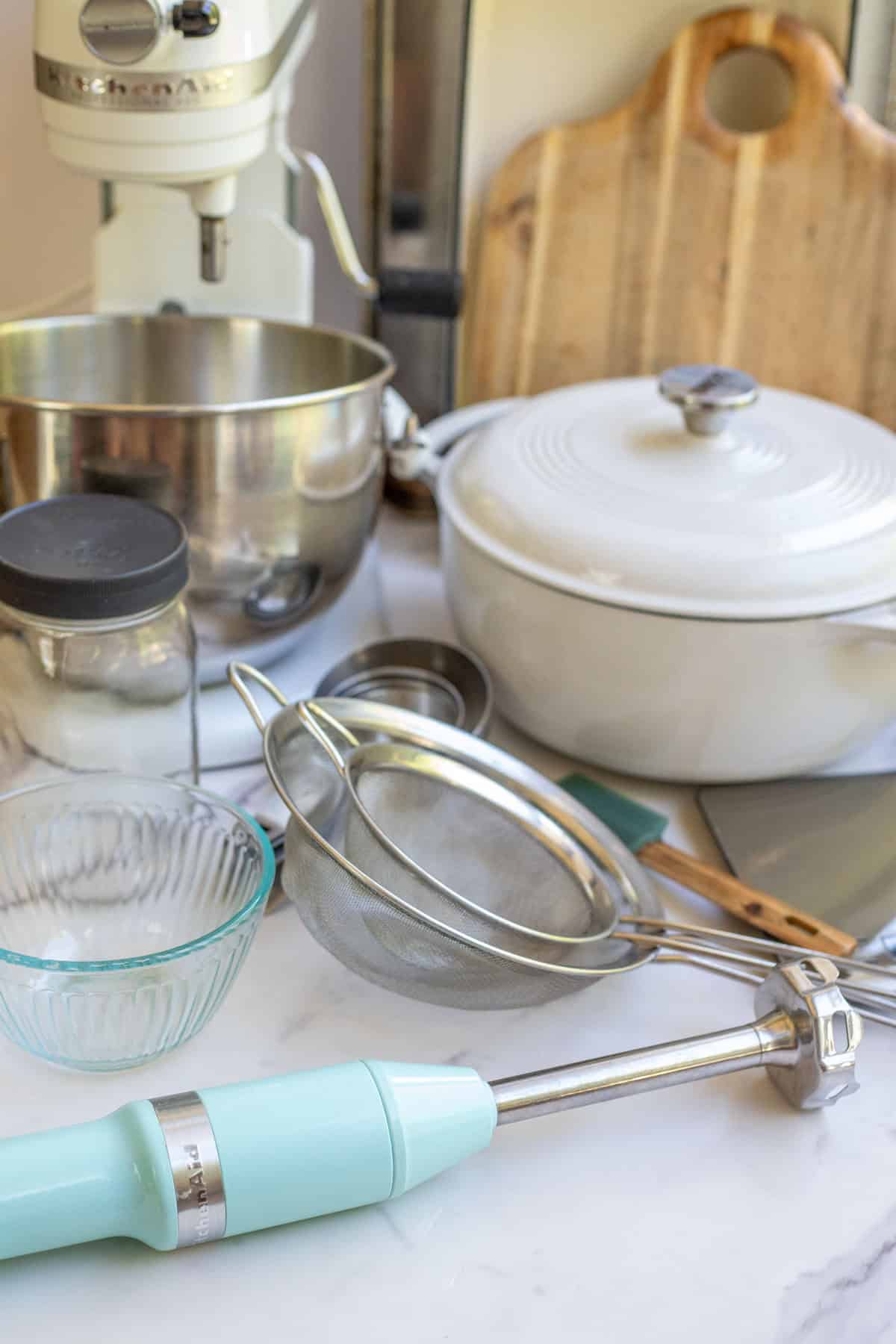 A variety of kitchen tools laying on the kitchen counter.