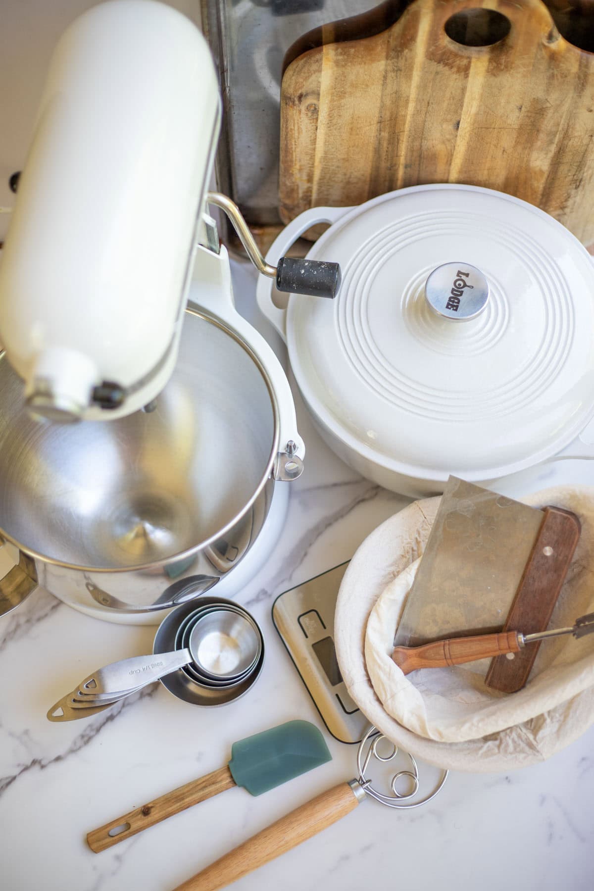 A KitchenAid mixer, Dutch oven, and other baking tools on the counter top.