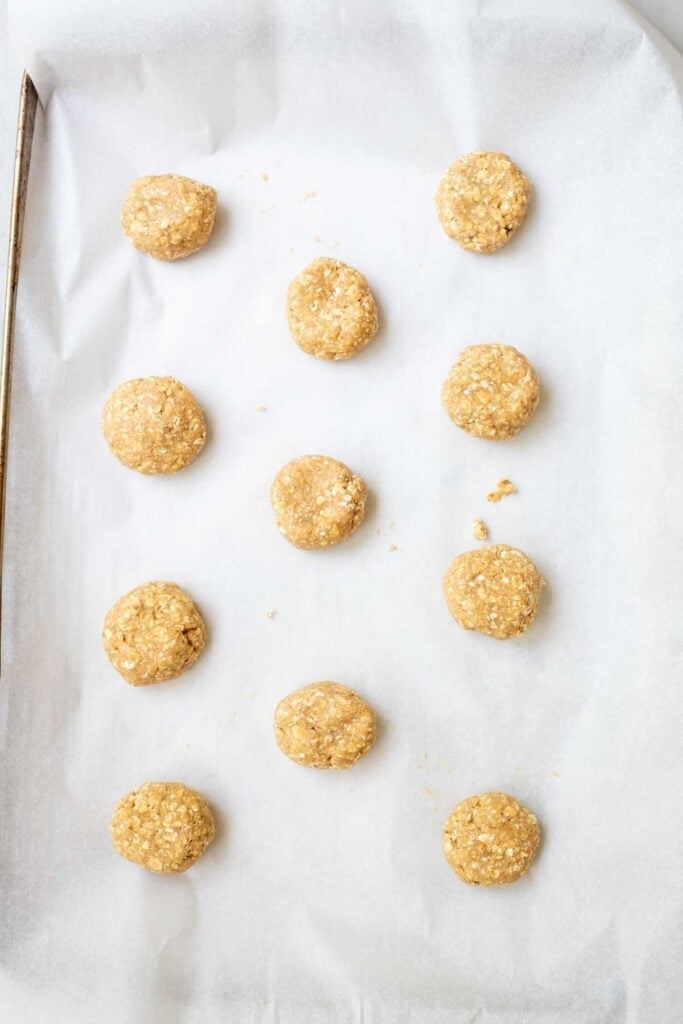 oatmeal cookies rolled into balls on parchment paper.