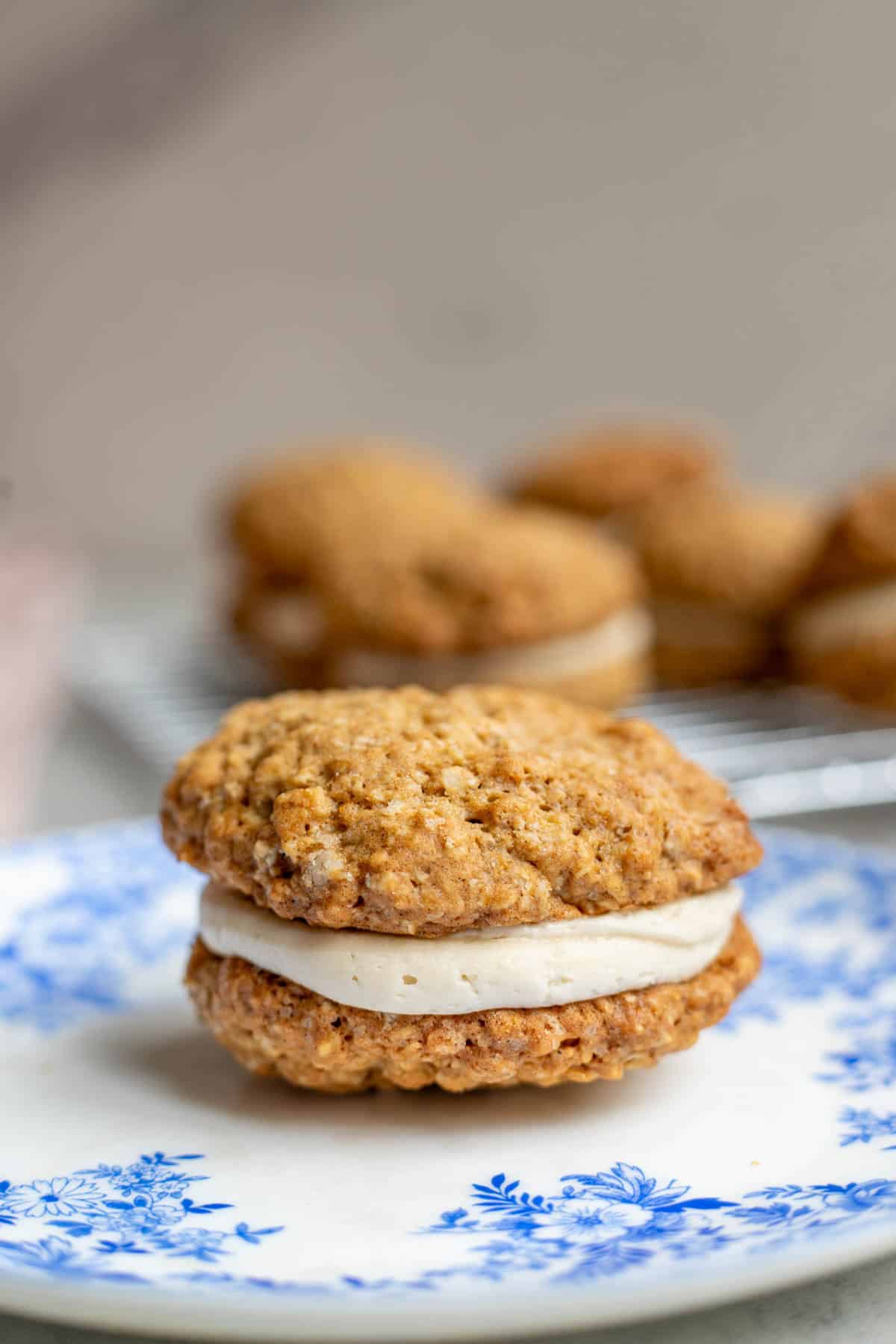 An oatmeal cream pie sitting on a blue plate.