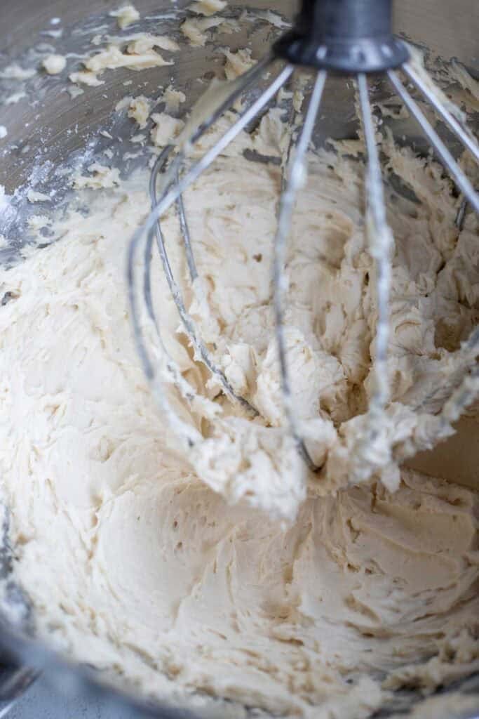 Sugar and cream cheese mixed together in a stand mixer.