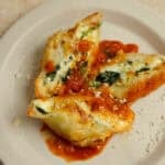 three stuffed ricotta cheese shells served on a white plate.