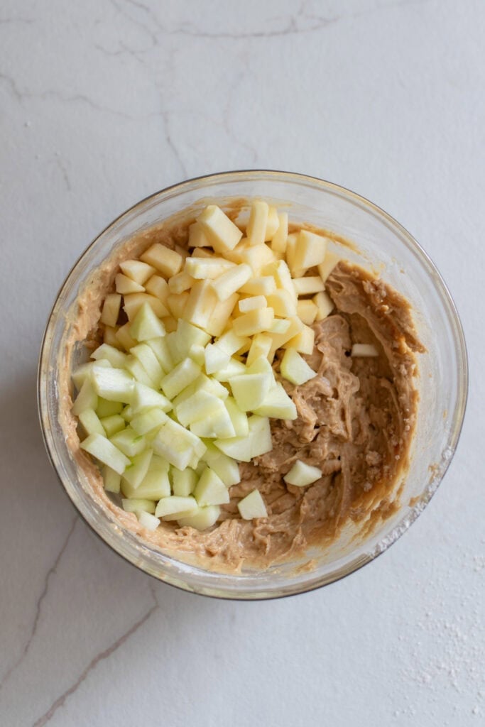 Folding chopped apples into cake batter.