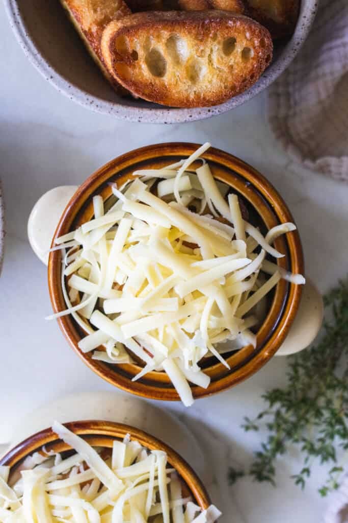 French onion soup in a bowl topped with fresh cheese.