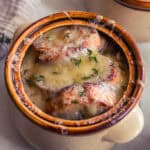 toasted baguette slices in a bowl of soup.