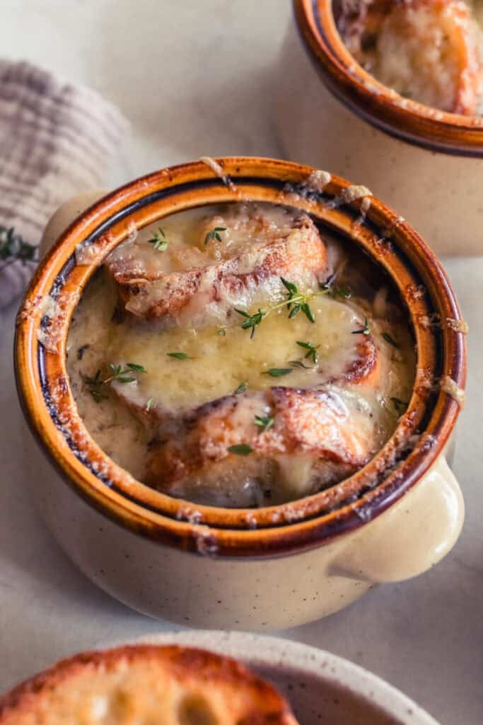 Toasted baguette slices in a bowl of soup.