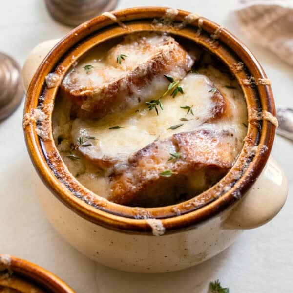french onion soup with fresh bread in a crock pot.