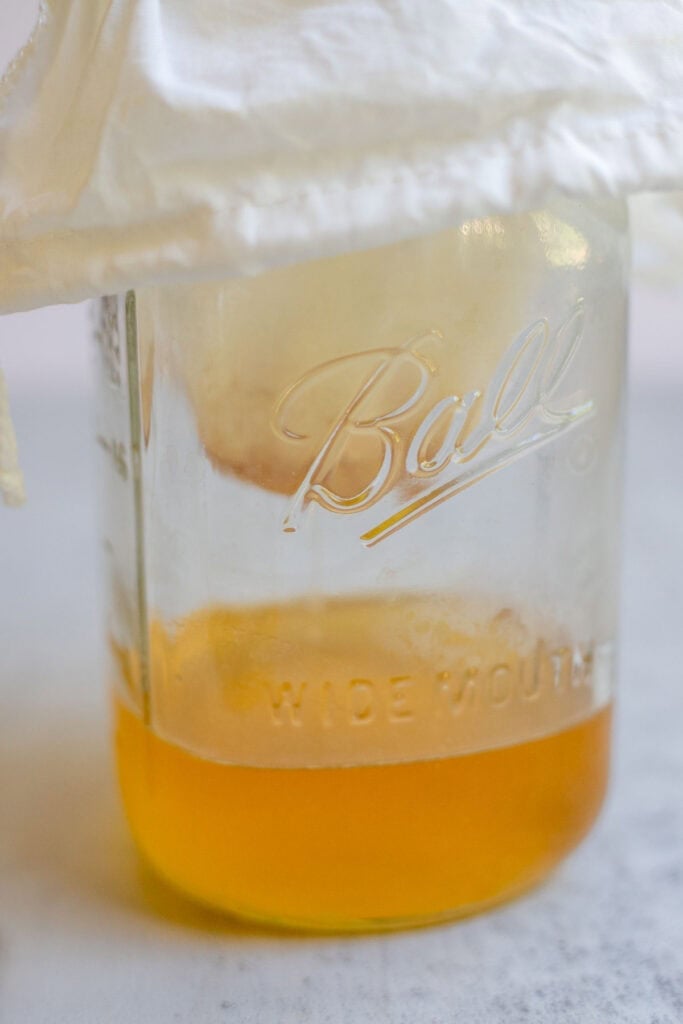 Butter being strained through a cheesecloth.