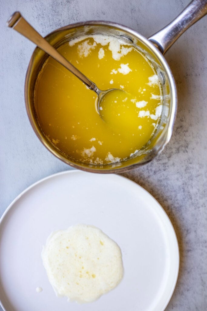 Melted butter in a simmer pot with a plate beside it. 