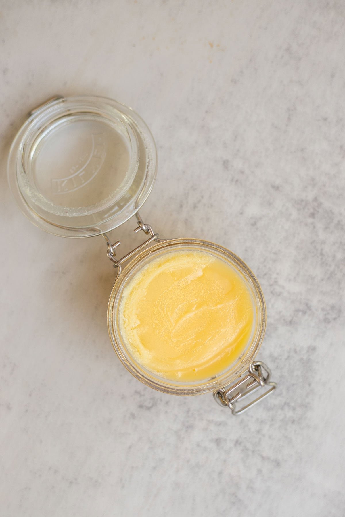An open glass jar filled with homemade ghee.