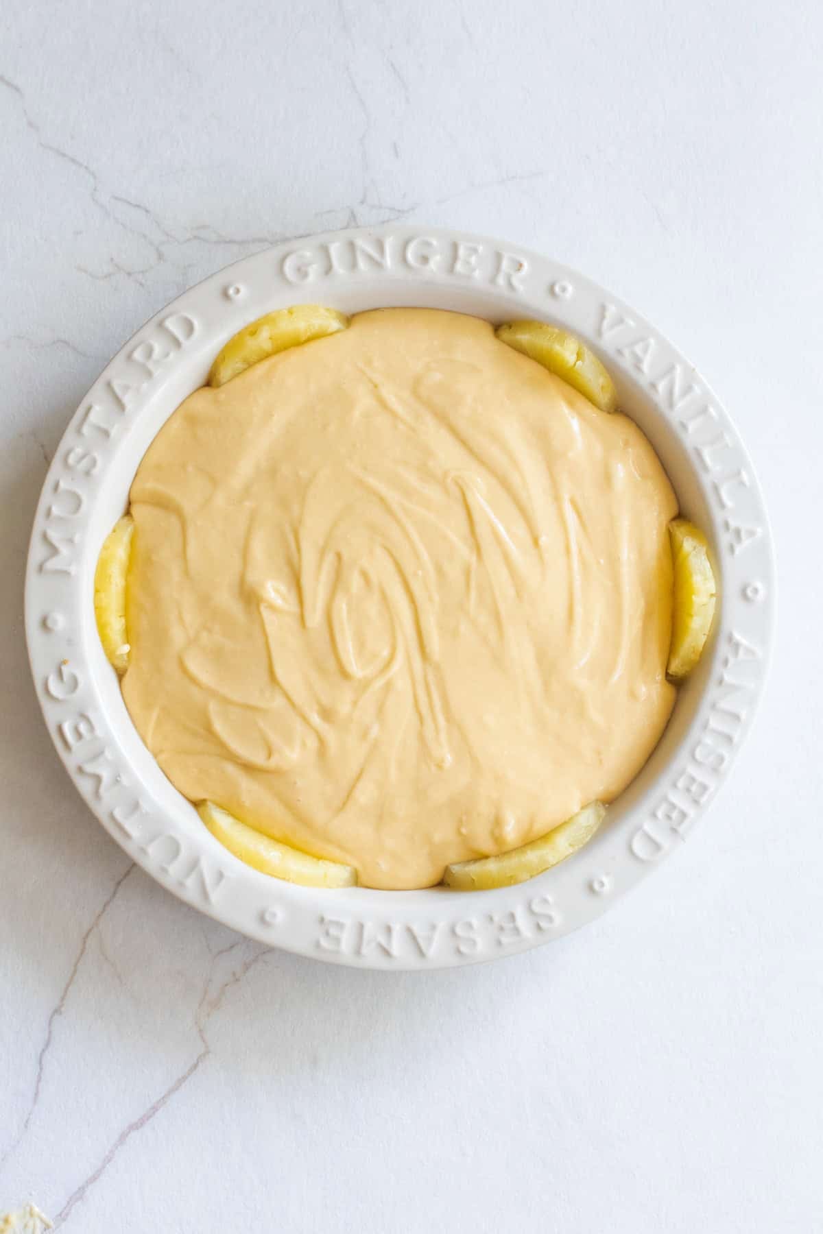 Unbaked pineapple upside down cake in a pie plate.