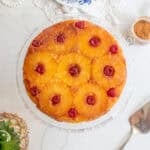 Overhead photo of a pineapple upside down cake on a glass cake plate.