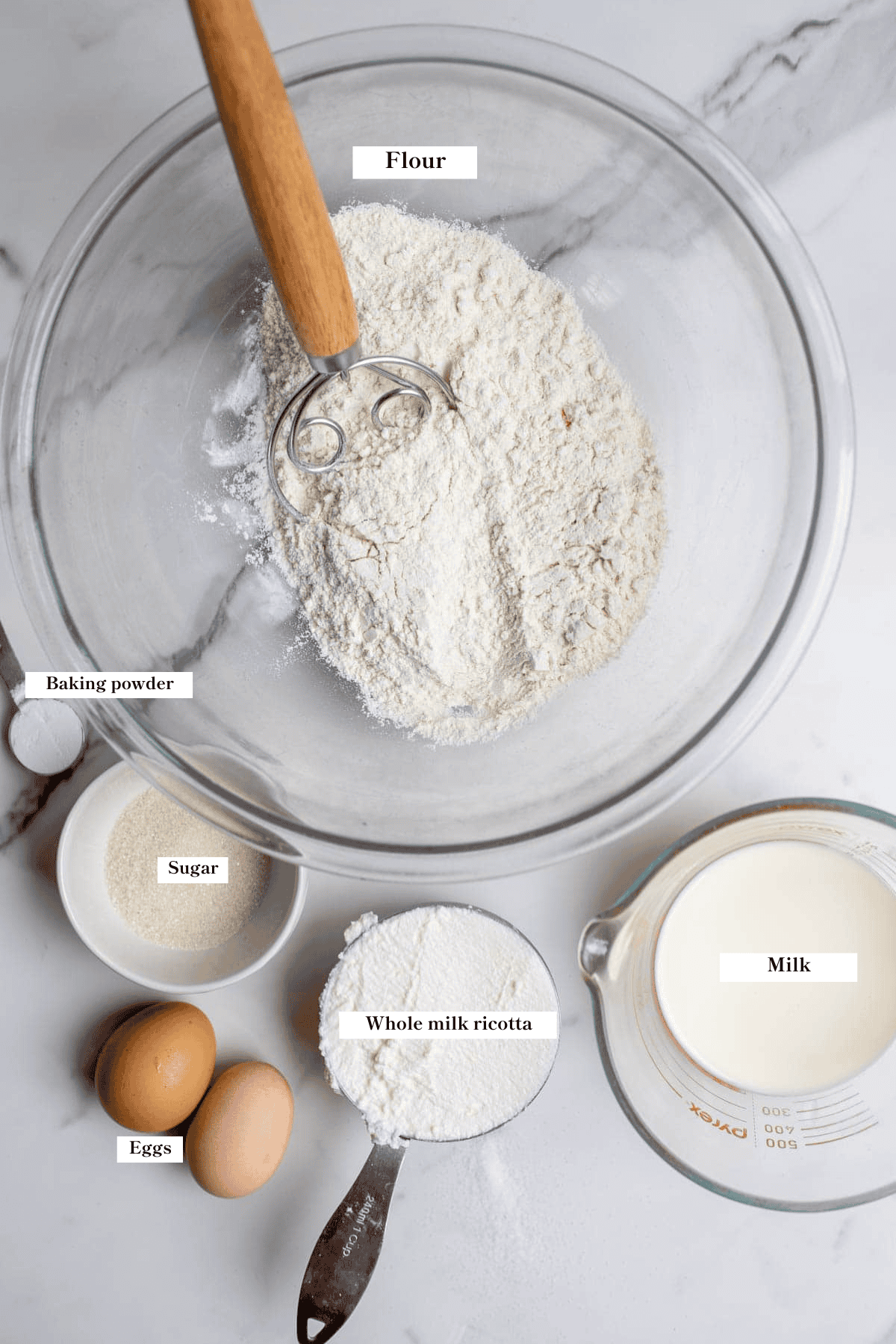 Flour, ricotta, milk, eggs, and sugar on the countertop