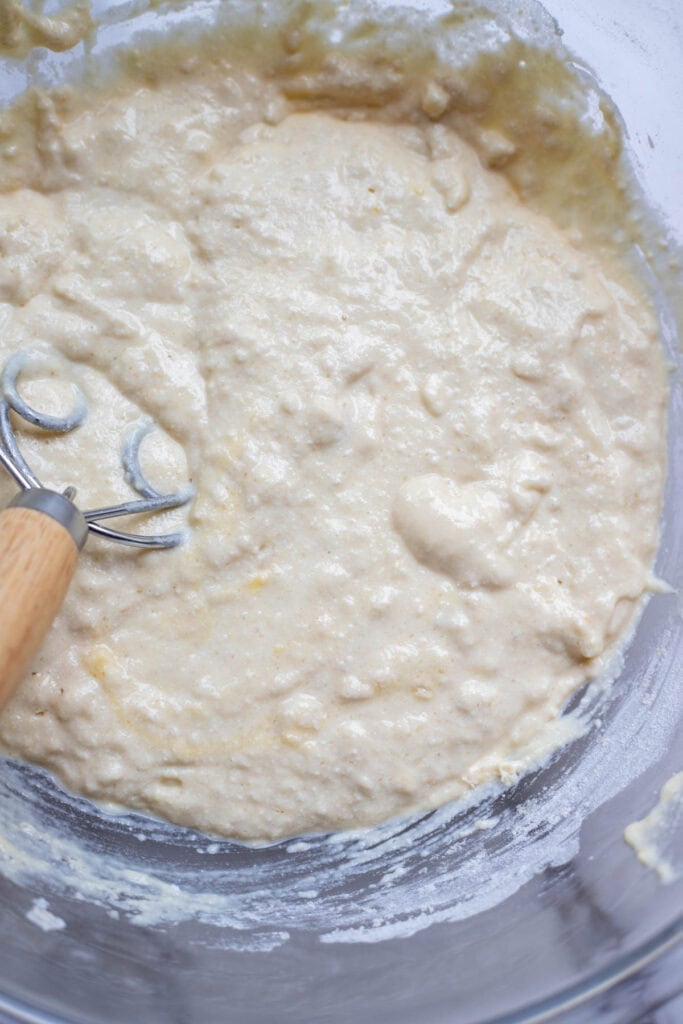 Ricotta cheese being added to a flour and sugar mixture for pancakes.