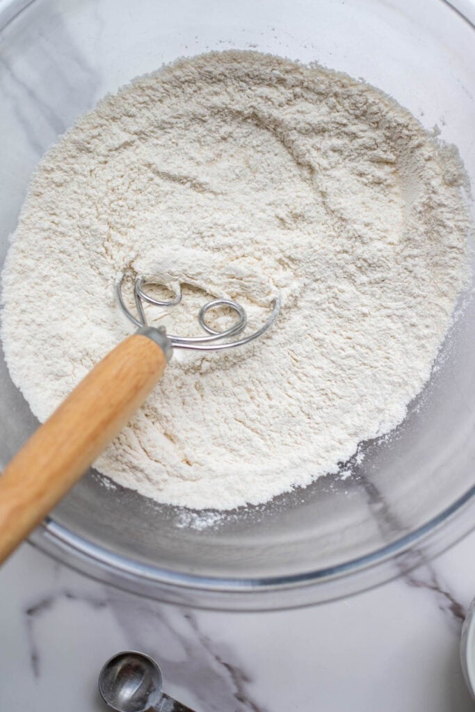 Dry ingredients being mixed together in a glass bowl.
