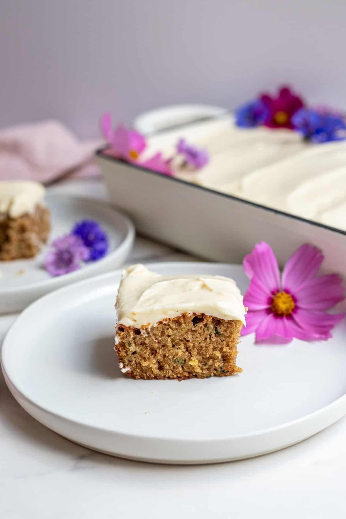 A slice of zucchini cake sitting on a white plate.