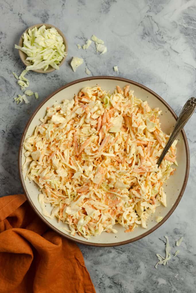 Fresh coleslaw in a bowl on the kitchen counter.