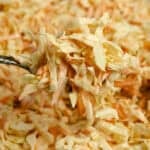 a fork lifting up a bite full of coleslaw.