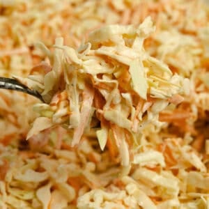 a fork lifting up a bite full of coleslaw.