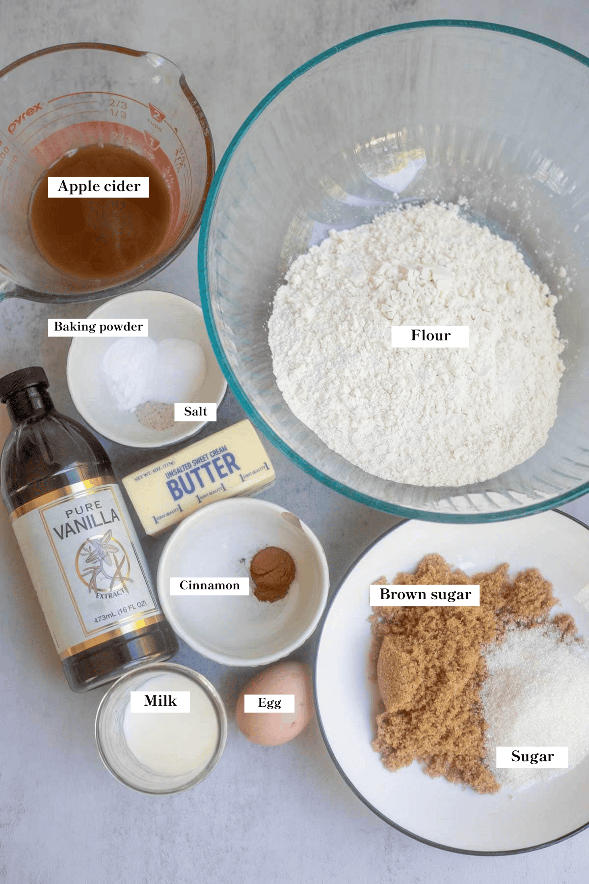 Flour, apple cider, sugar, butter, vanilla, and other ingredients on the counter.