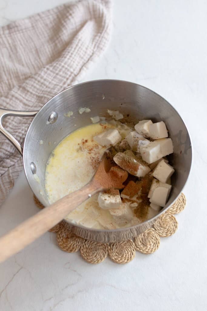 Cream cheese cubes added to a small sauce pan.
