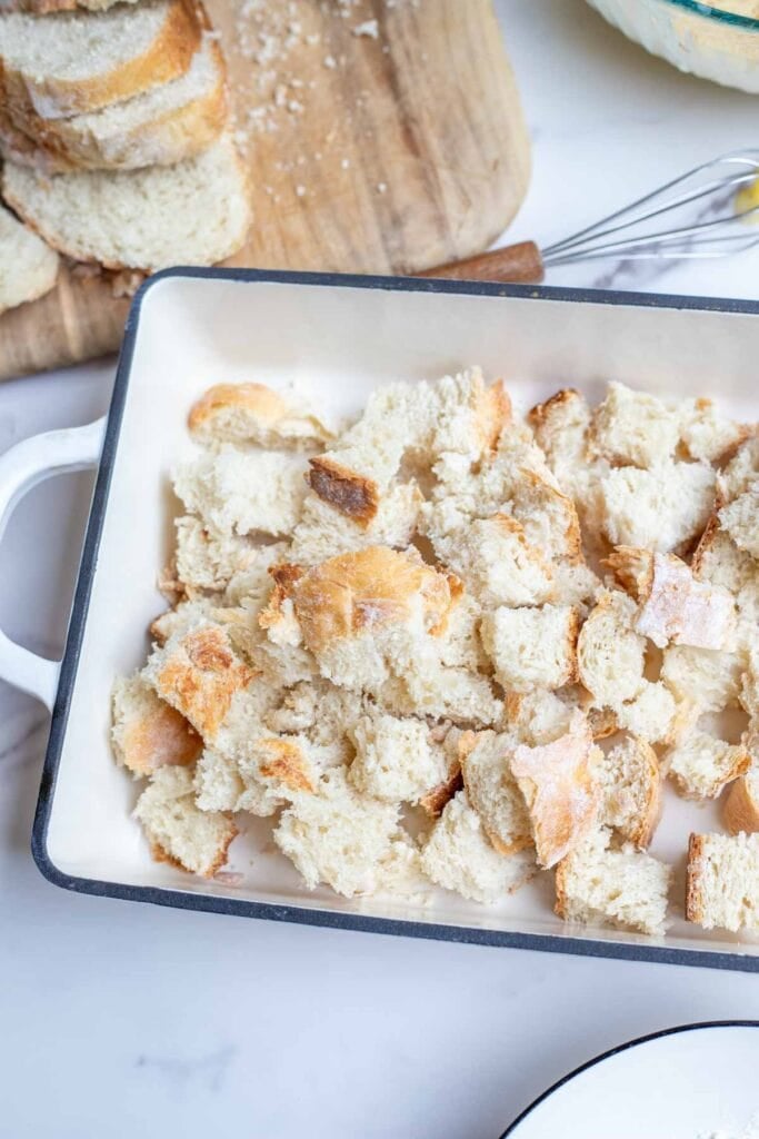 Sourdough bread cut into cubes in a cast iron baking dish.