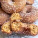 donuts on a cooling rack with one of them split in half.