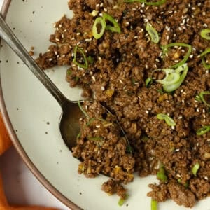 Korean beef topped with sliced green onions in a plate.