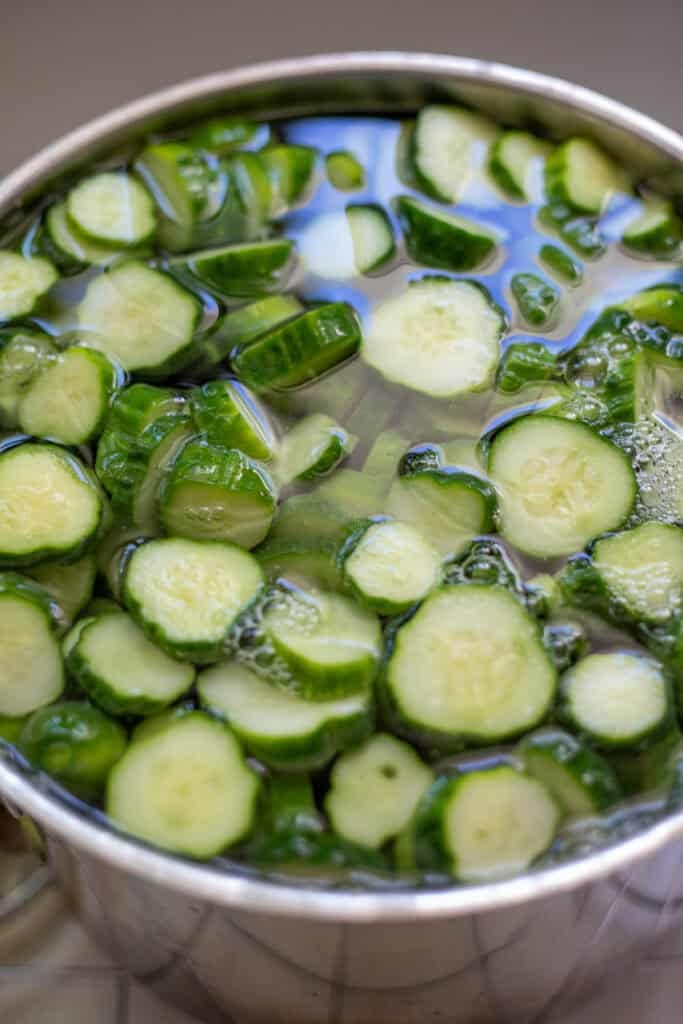 Cucumber slices soaking in a pickling lime solution.