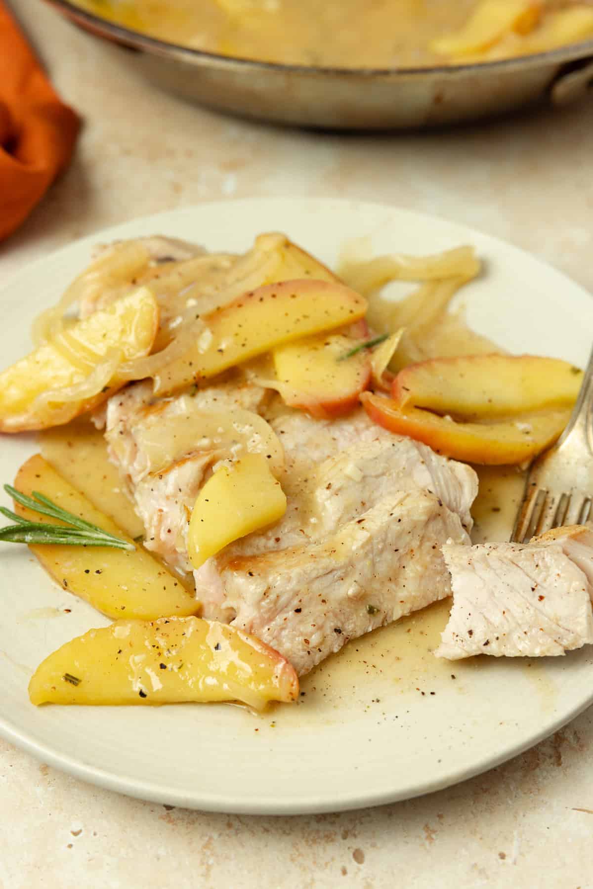 A plate full of pork chop with sautéed apples and onions.