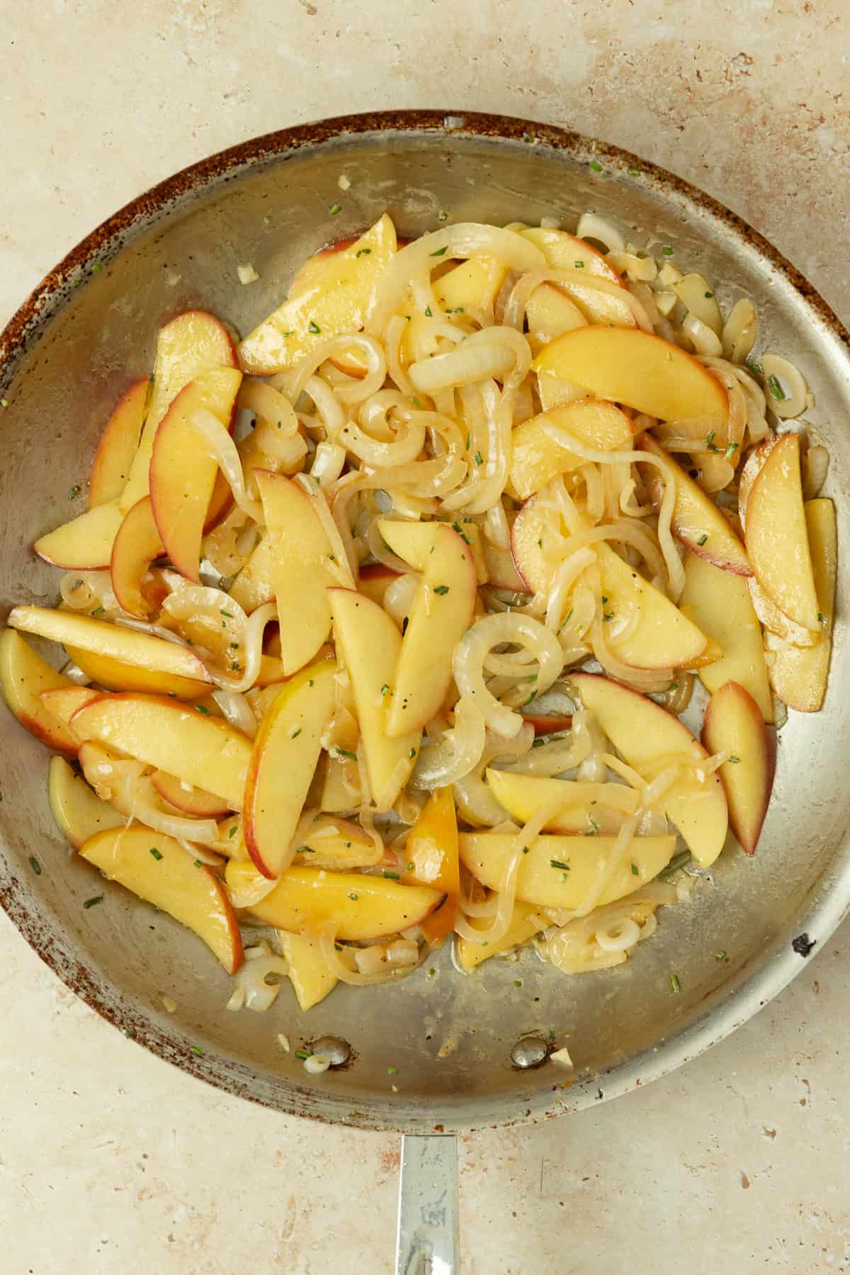 Skillet of apples and onions sautéing.