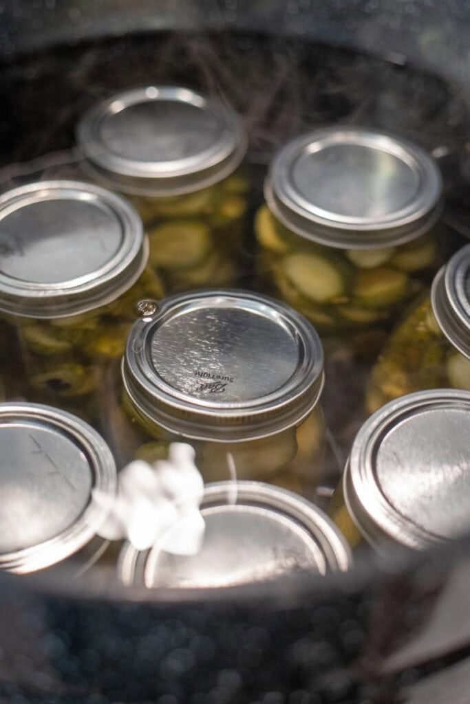 Jars of canned food sitting in a large pot of water.