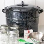 canner, tools, and jars sitting on the counter top.
