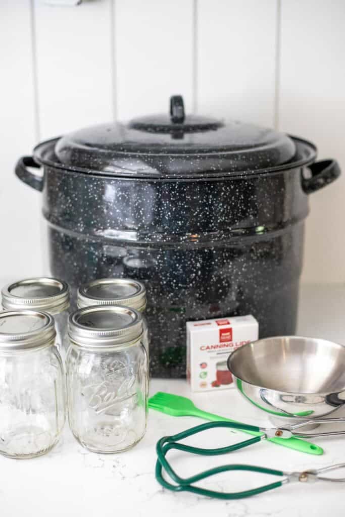 Canner, tools, and jars sitting on the counter top.