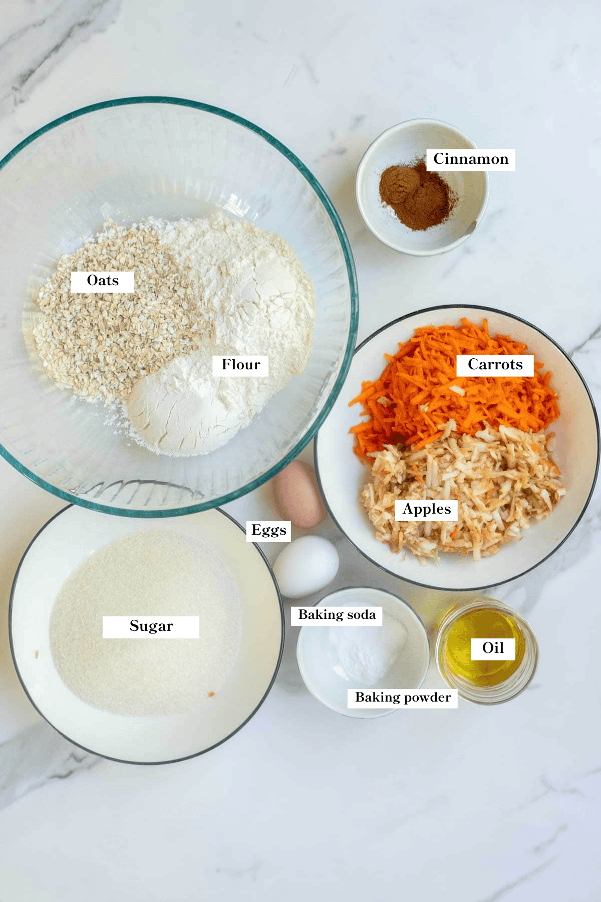 flour, carrots, apples, sugar, oil, and more ingredients on the counter.