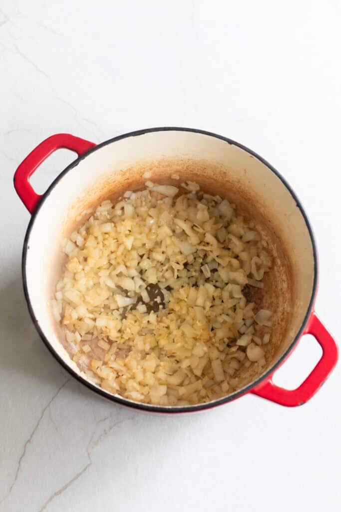 Onions added to a Dutch oven.