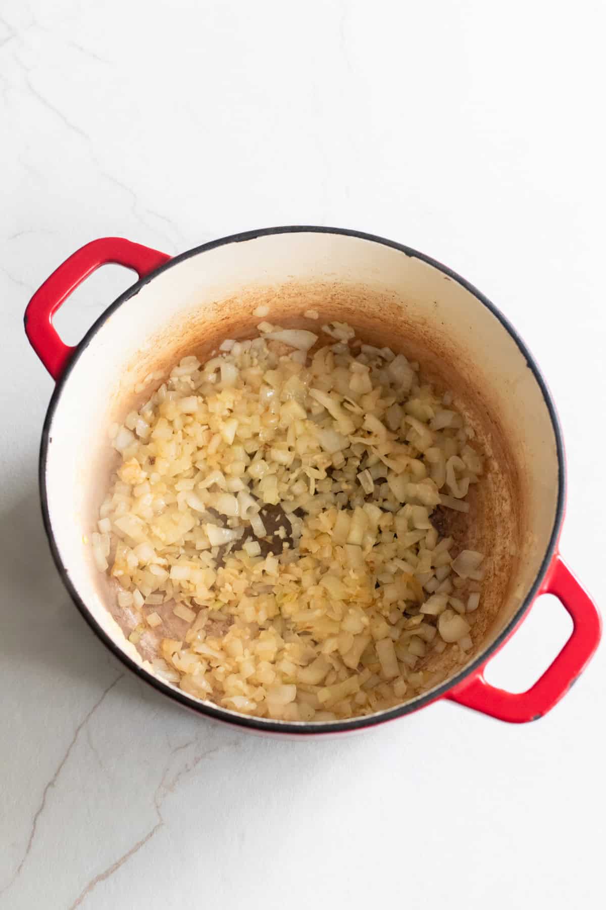 Onions added to a Dutch oven.