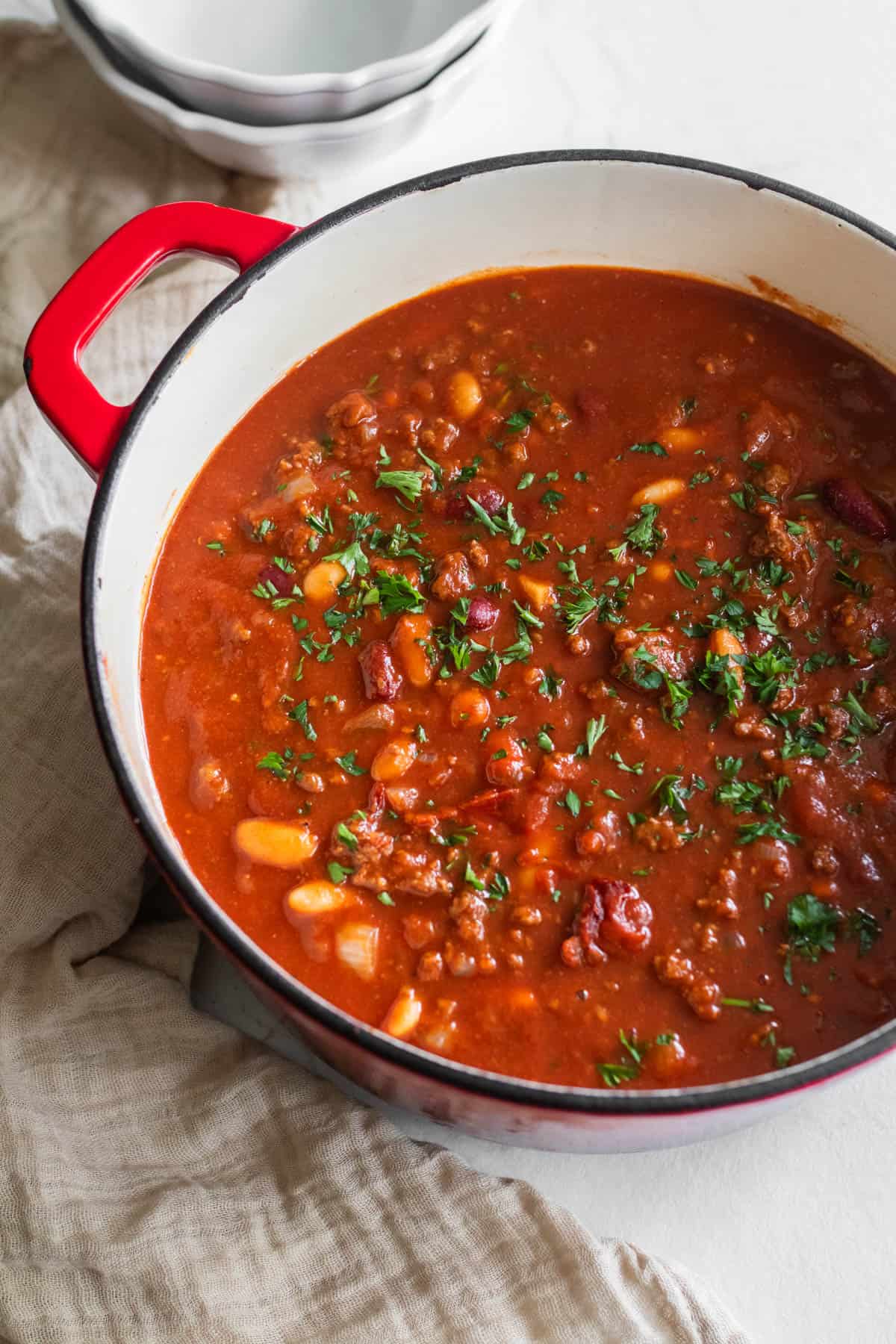 Ground beef chili in a Dutch oven on a countertop.
