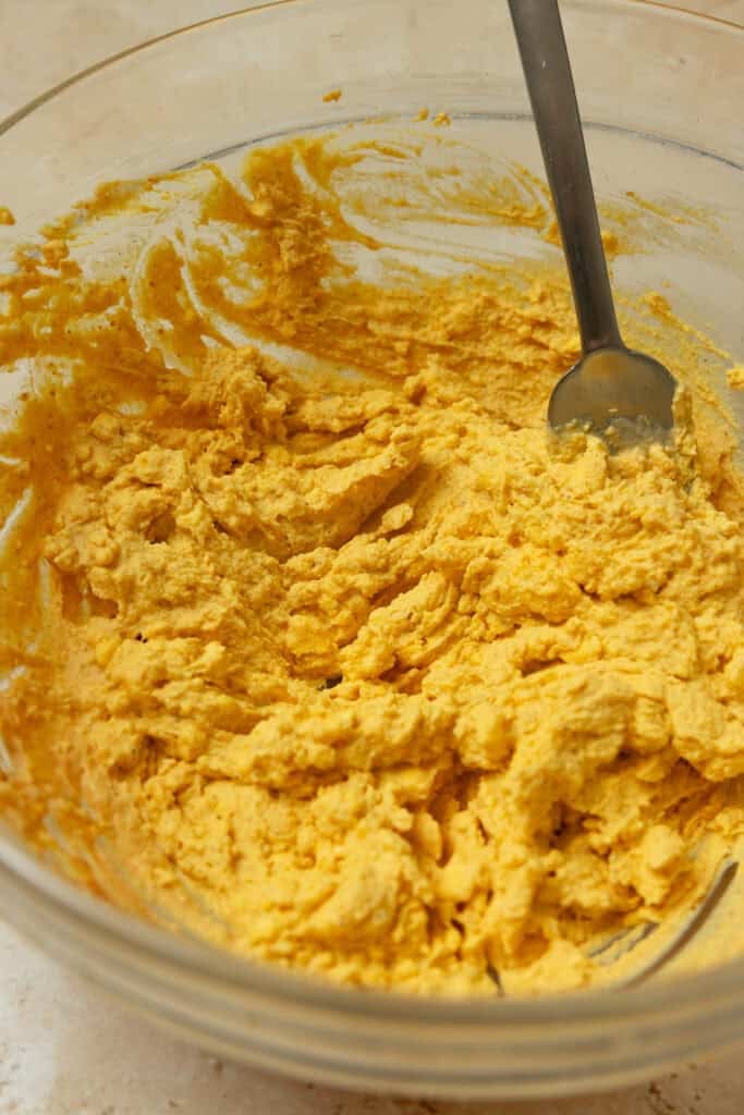 Mash egg yolk mixture in a glass bowl.