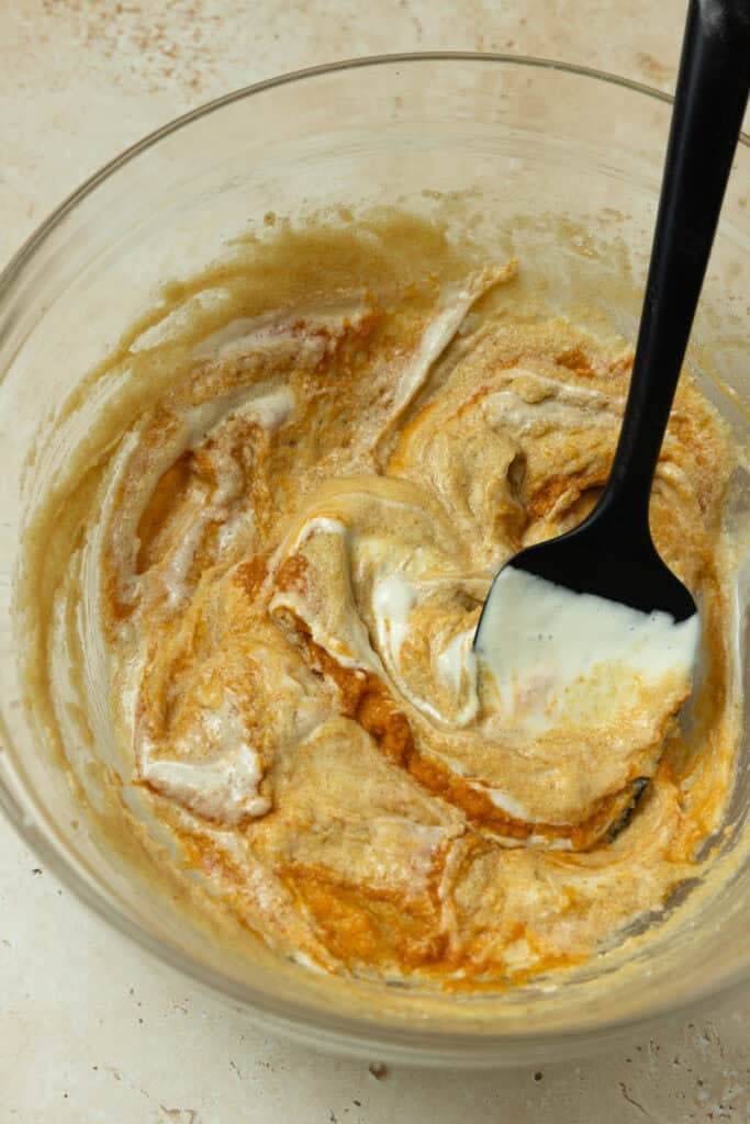 A spatula mixing together ingredients in a bowl.