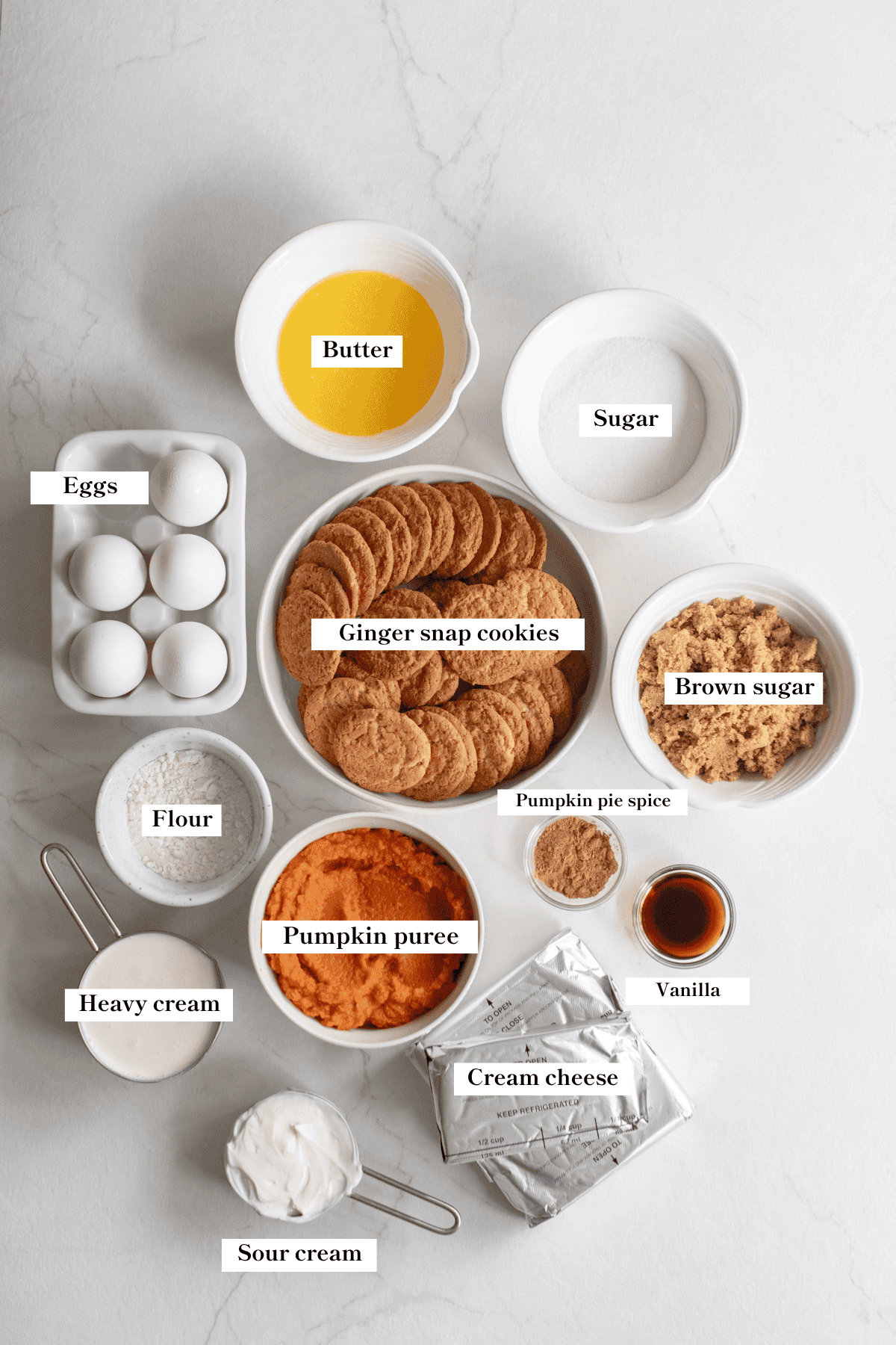 Ginger snap cookies, brown sugar, eggs, vanilla, pumpkin puree and other ingredients on the counter. 