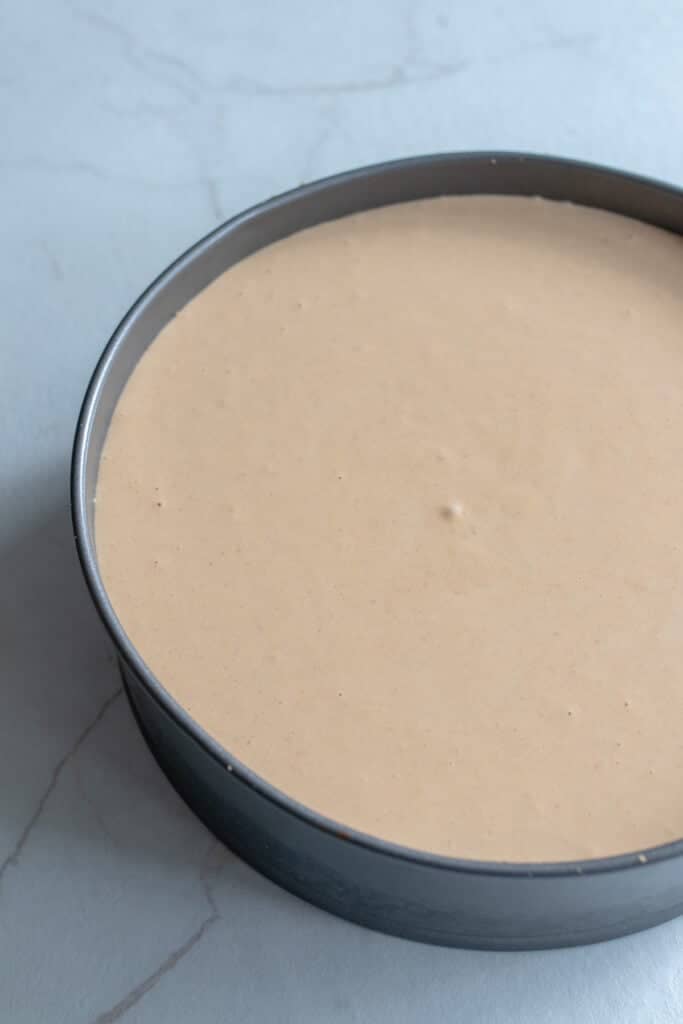 Pumpkin cheesecake batter poured into the crust lined pan. 