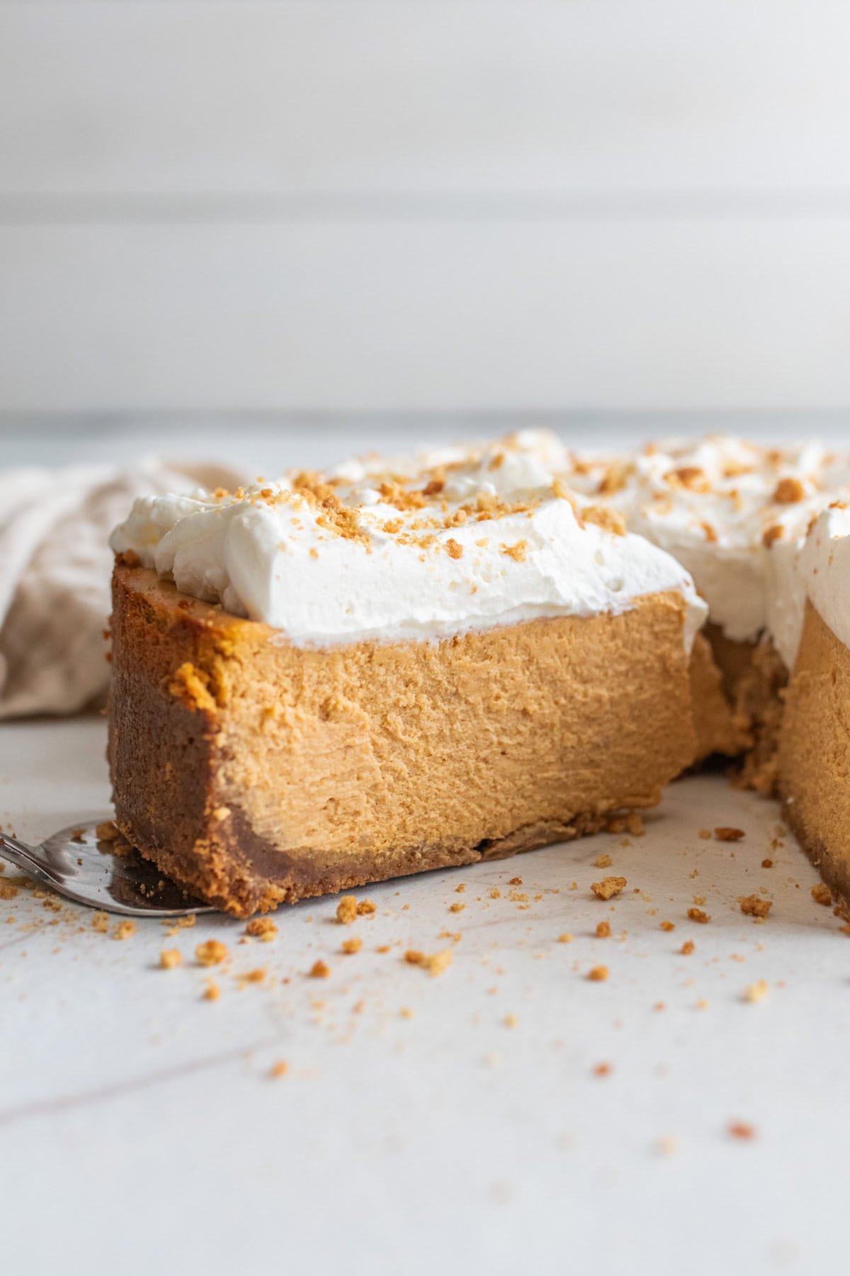 a slice of pumpkin cheesecake on a cake platter.