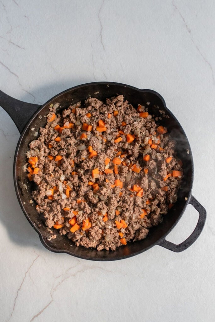Ground beef and veggies in a skillet.